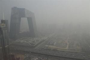 The China Central Television (CCTV) building is seen next to a construction site in heavy haze in Beijing